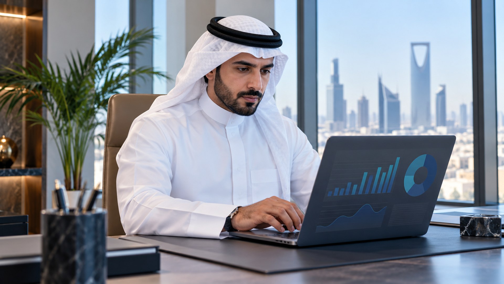 شخص يحدّث رسوماً وبيانات في مستند رقمي على اللابتوب