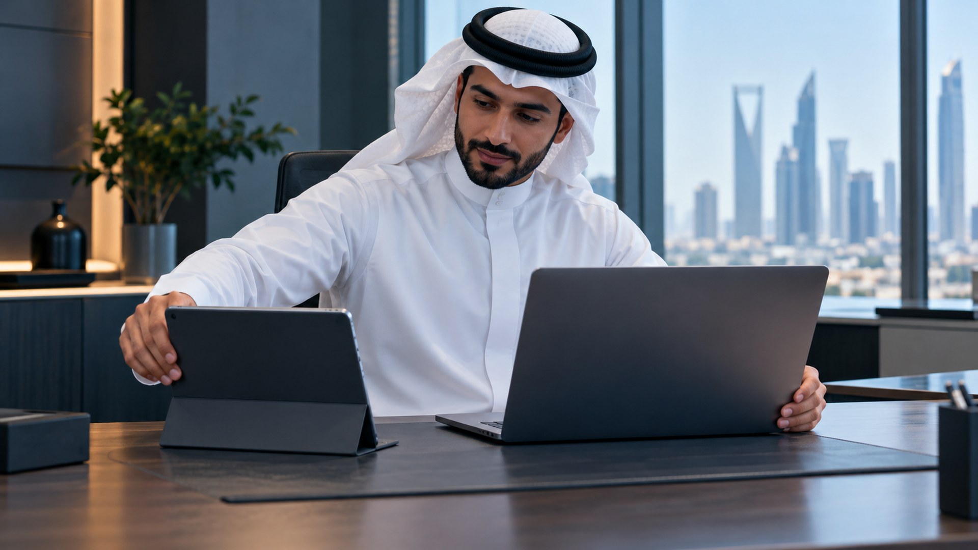 موظف سعودي يجهز لابتوب وجهازاً لوحياً جديدين على مكتب نظيف