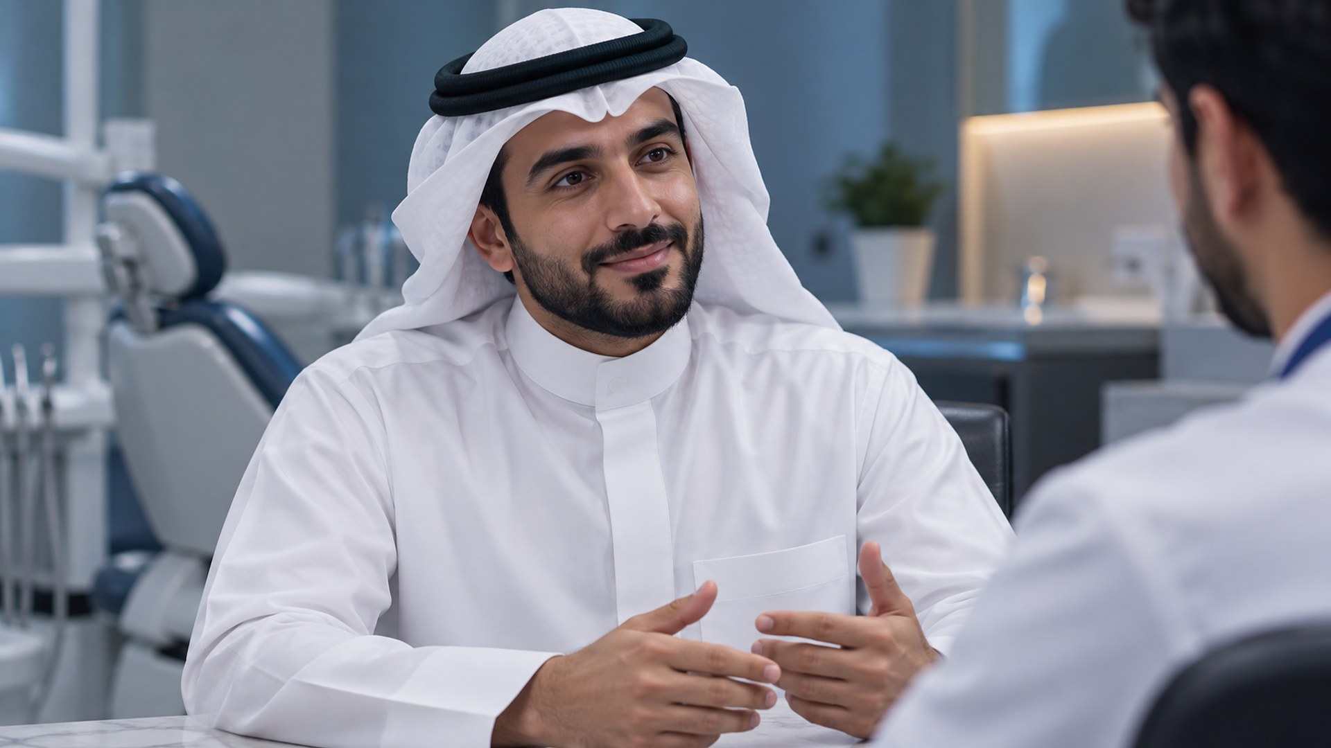رجل سعودي يناقش خطة علاج أسنانه بهدوء مع الطبيب