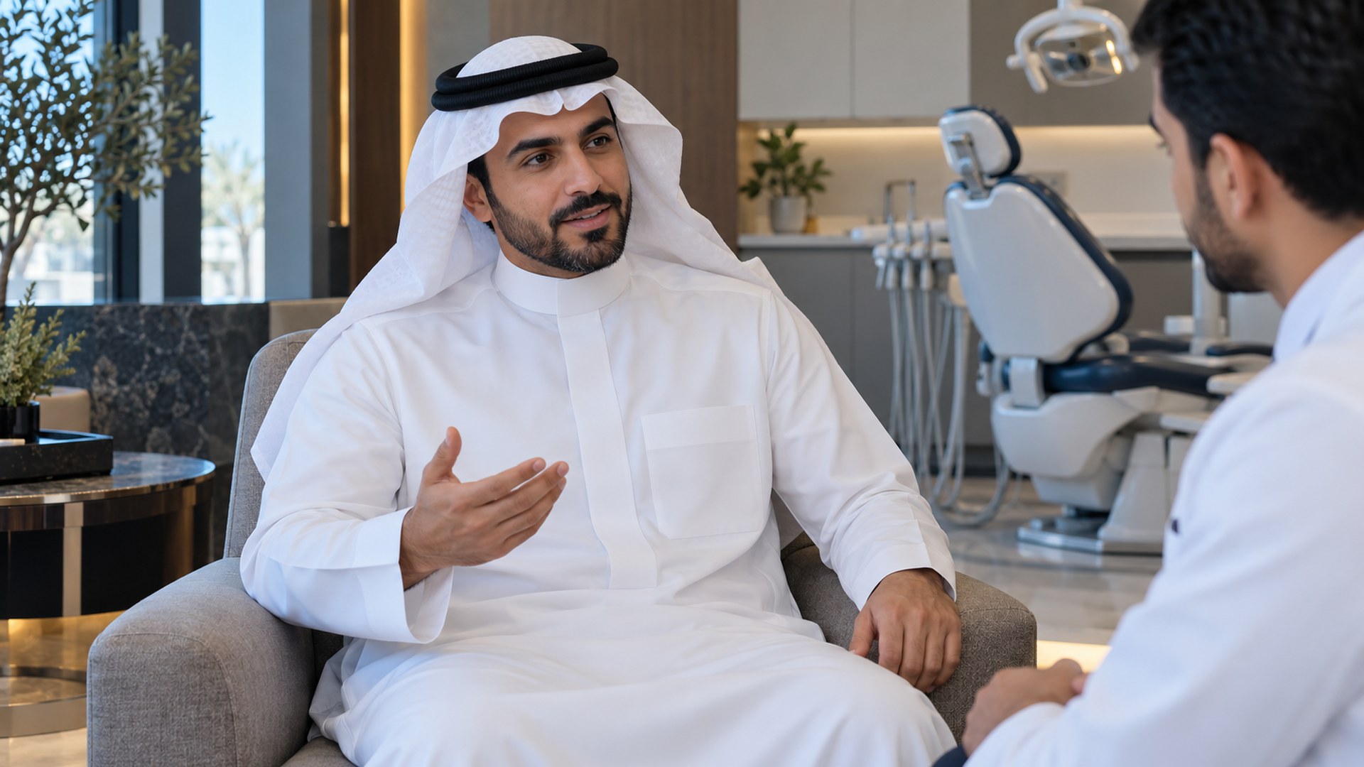رجل سعودي يناقش ابتسامته مع طبيب الأسنان في غرفة استشارة هادئة