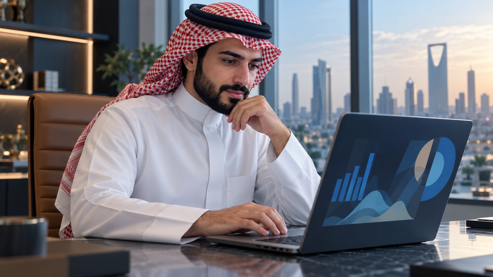 مسوّق سعودي يراجع لوحة تحليلات على اللابتوب بهدوء