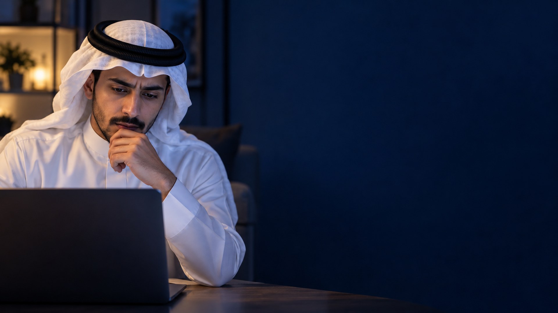 متقدم للجامعة سعودي متردد أمام اللابتوب في مكتب البيت