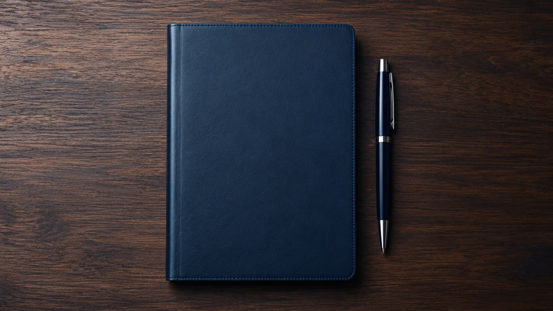 دفتر وقلم على مكتب مرتب، من الأعلى