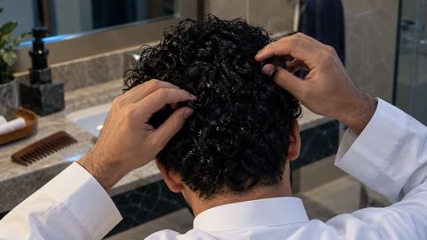 أصابع تفك تشابك شعر مجعد رطب ببطء من الأطراف للأعلى