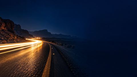 خط ضوء يندفع على طريق مظلم ليلاً