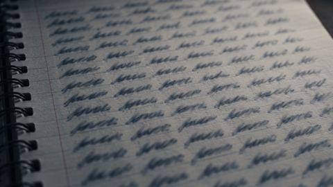 صفحة دفتر مكتوبة فيها نفس الكلمة مرات كثيرة