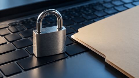 قفل على لوحة مفاتيح لابتوب بجانب ملف