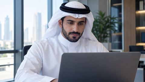 محرر سعودي يراجع شاشة اللابتوب بهدوء في مساحة عمل مضيئة