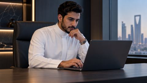 رائد أعمال سعودي يتابع مؤشرات أداء موقعه على اللابتوب
