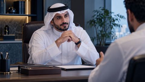 كاتب سعودي يستمع باهتمام لشخص أمامه على مكتب