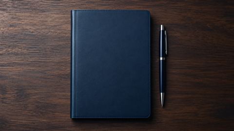 دفتر وقلم على مكتب مرتب، من الأعلى
