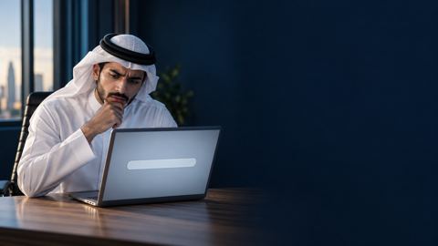 شاب سعودي بالثوب والغترة محتار أمام خانة بحث فارغة على لابتوبه
