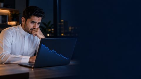 شاب سعودي قلق أمام لابتوب يعرض انخفاض زيارات موقعه في مكتب منزلي ليلاً